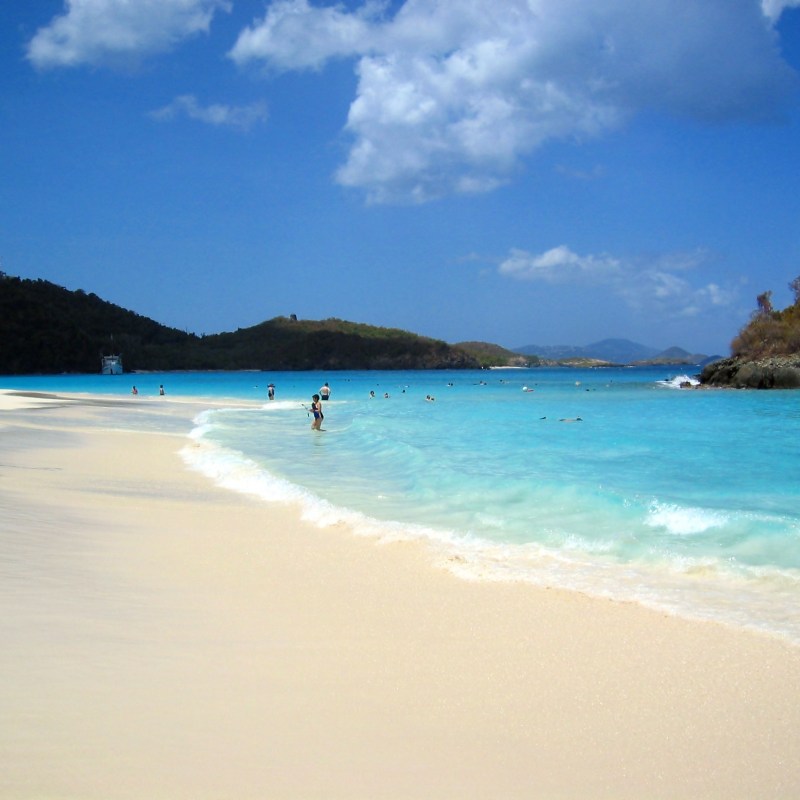 a sandy beach next to a body of water