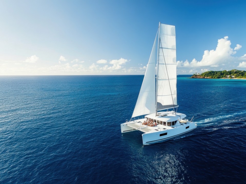 Sleek modern catamaran sailing over calm blue waters caribbean sea aerial view travel adventure marine experience ships in tranquil environment