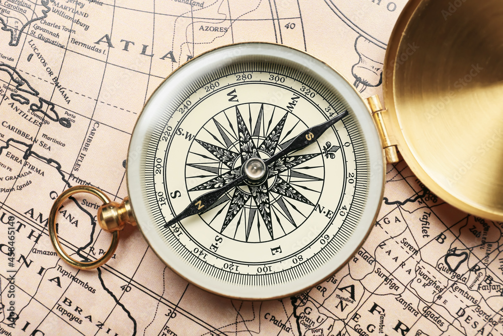 Vintage compass over a map showing parts of the Atlantic Ocean and landmasses.